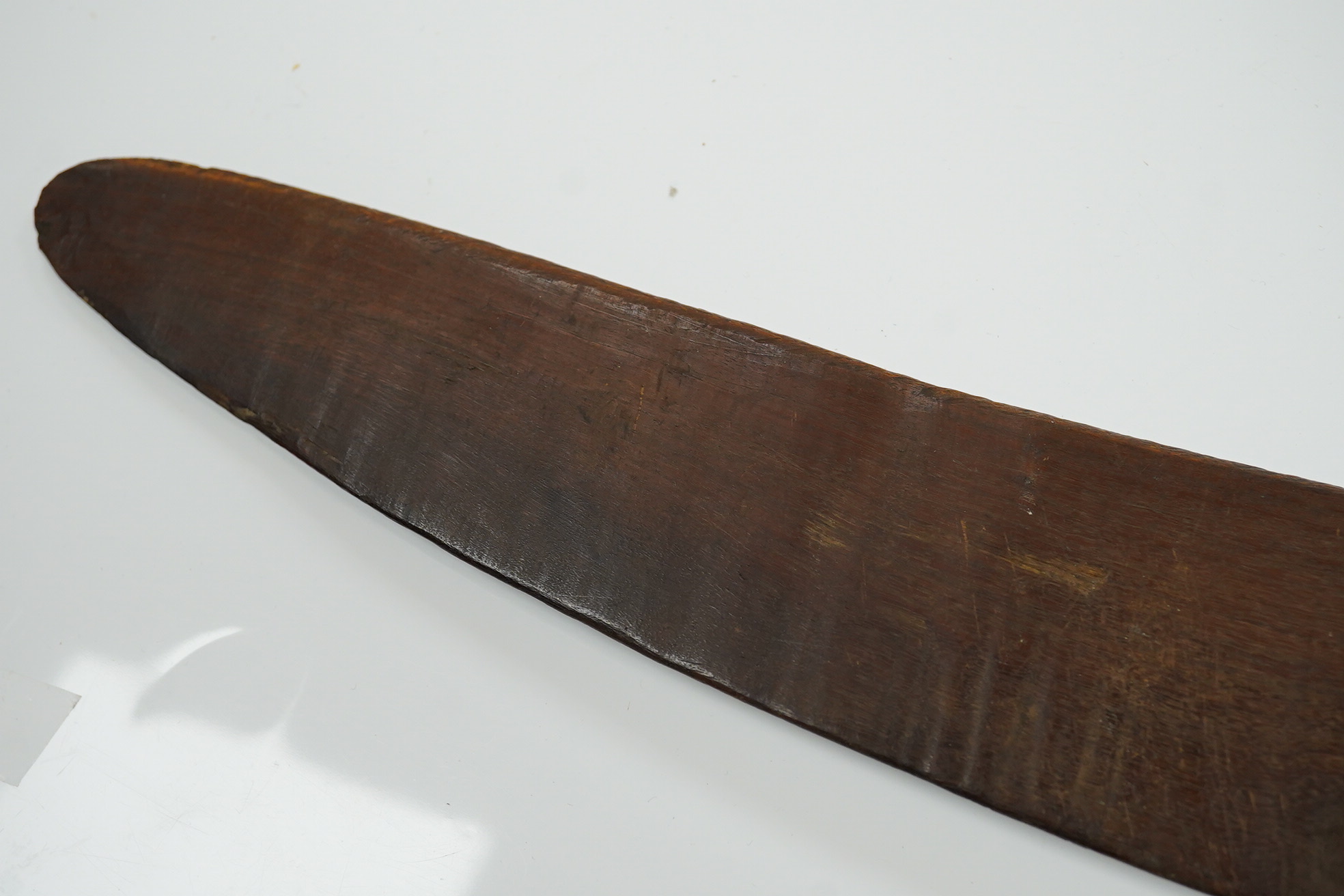 An Aboriginal boomerang, engraved to one side, 76cm wide. Condition - fair to good